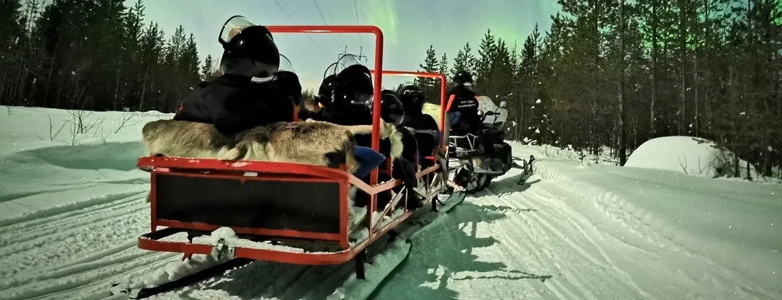 Northern lights sledge ride by snowmobile